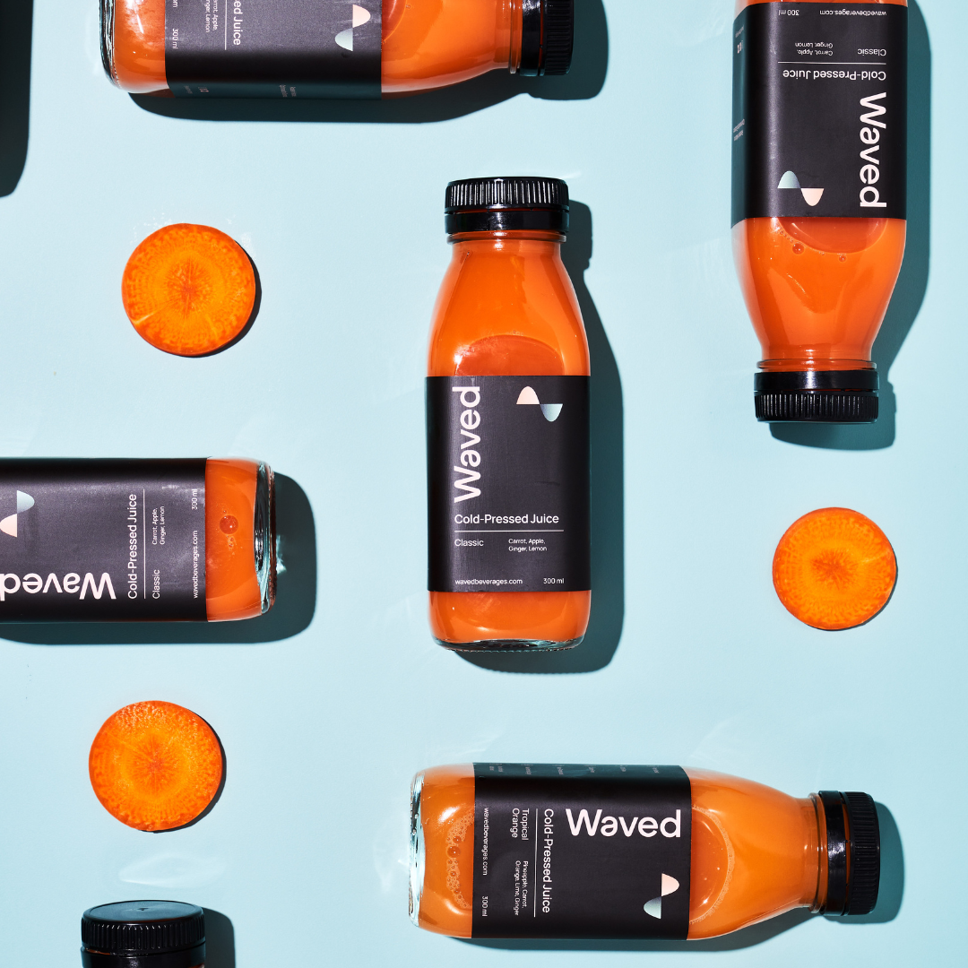 Symmetrical Arrangement Of Waved Tech-Optimised Cold-Pressed Juice, Classic With Carrot, Apple, Ginger and Lemon